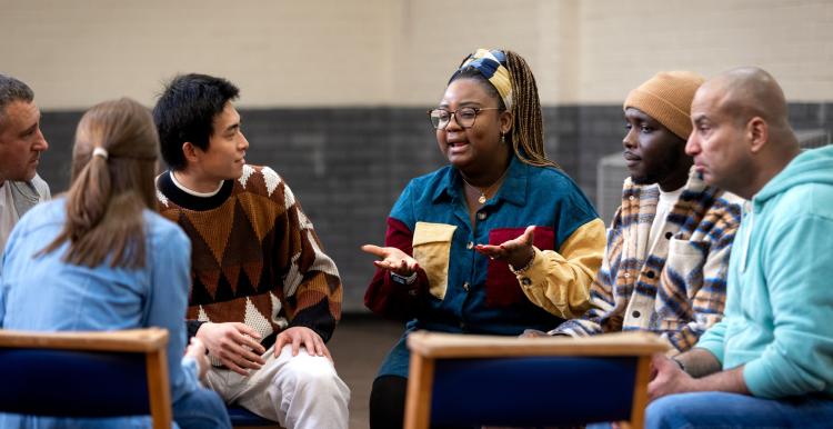 Group of adults sitting in a circle and talking to each other about their mental well-being