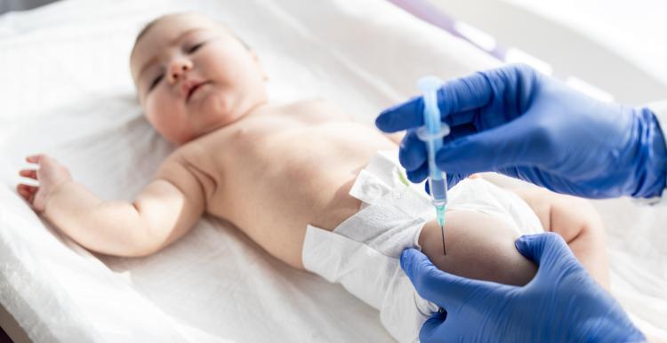 Doctor giving vaccine shot to baby