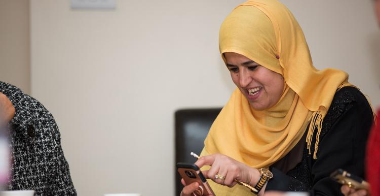 Woman in head scarf learning about her smartphone at a digital inclusion event