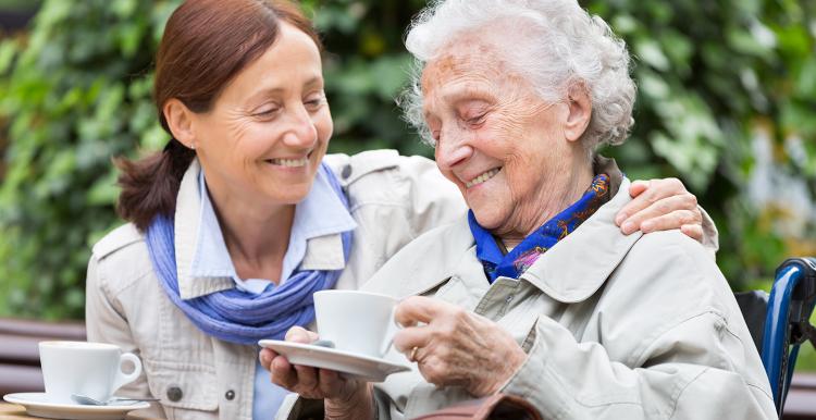 Smiling middle aged woman caring for her mother