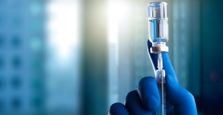 Doctor holds syringe and bottle with vaccine.