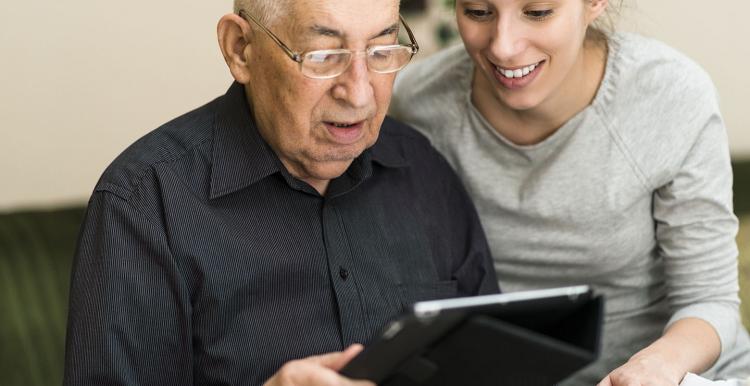 Older man and younger woman looking at a tablet