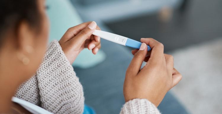 Woman taking a pregnancy test at home