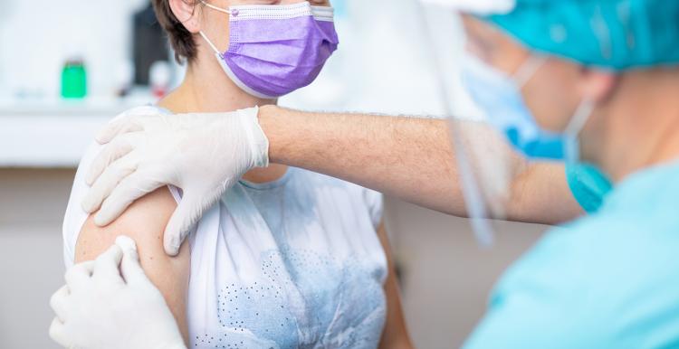 Woman in a facemask preparing for a vaccination