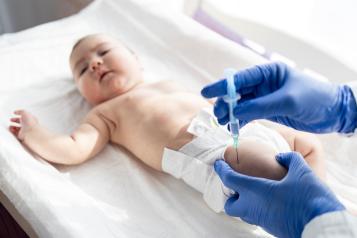 Doctor giving vaccine shot to baby